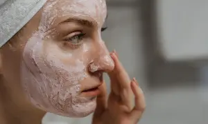 Frau mit Gesichtsmaske, die ihre Haut mit probiotischer Hautpflege pflegt.