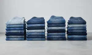 Stapel von Jeanshosen in verschiedenen Blautönen. Sie zeigen, aus was Jeans bestehen: robustem Denim-Stoff.