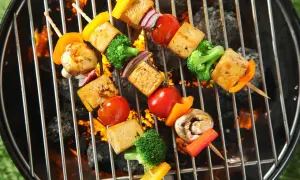 Vegane Grillrezepte: Bunte Gemüsespieße mit Tofu, Paprika, Brokkoli und Tomaten brutzeln auf dem Grill über glühender Kohle.