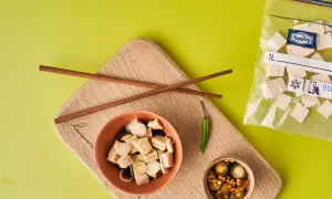 Vorbereitung für tofu einfrieren: gewürfelter Tofu in Schüssel mit Soße, daneben ein kleiner Chili und ein Beutel mit gefrorenem Tofu.