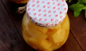 Ein Glas mit leckerem Quittenkompott, liebevoll mit einem gemusterten Papier und Juteband verschlossen.