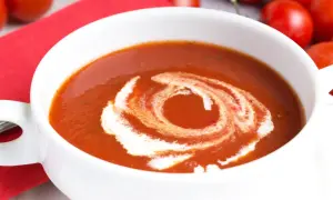 Eine cremige Tomatensuppe, perfekt für ein Tomatensuppe Rezept mit frischen Tomaten. Mit einem Swirl aus Sahne verziert.