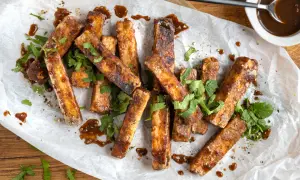 Marinierter Tofu, knusprig gebraten und mit einer dunklen Sauce beträufelt, garniert mit frischem Koriander. Perfekt zum **Tofu marinieren** und Genießen.