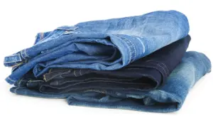 Gestapelte Jeans in verschiedenen Blautönen. Die Herstellung von Jeans verbraucht viel Wasser.