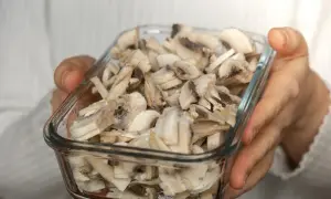 Gefrorene Champignons in einem Glasbehälter, bereit zum Einfrieren.