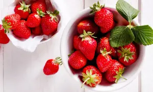 Frische, rote Erdbeeren in einer Schale und einem Körbchen, bereit, um sie frisch zu halten.