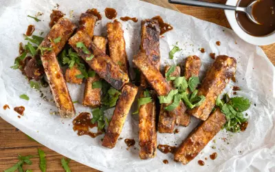 Marinierter Tofu, knusprig gebraten und mit einer dunklen Sauce beträufelt, garniert mit frischem Koriander. Perfekt zum **Tofu marinieren** und Genießen.