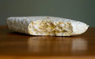 Ein Block Tempeh liegt auf einem Holztisch. Perfekt, um ihn für später einzufrieren.