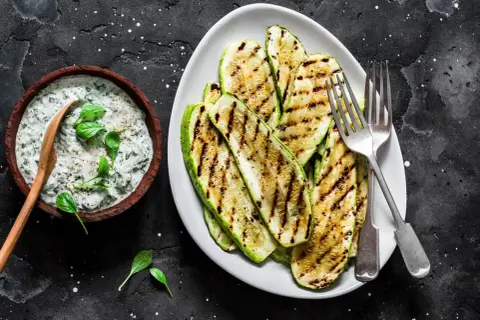 Perfekt gegrillte Zucchinischeiben mit Kräuterquark. Ein Genuss für jeden Grillabend!