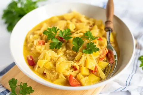 Herzhaftes Gericht mit Kartoffeln und Kohl, garniert mit Petersilie. Eine köstliche Currykraut-Verwendung für eine wärmende Mahlzeit.