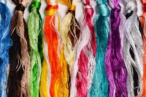 Bunte Fäden aus Maulbeerseide, die für tierfreundliche Stickereien verwendet werden.