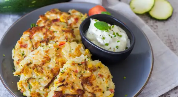 Herzhafte Reispuffer mit Zucchini und Paprika, perfekt, um Reis zu verwerten. Dazu ein Dip mit Kräutern.