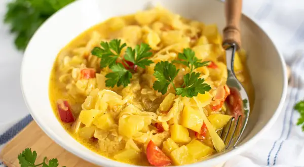 Herzhaftes Gericht mit Kartoffeln und Kohl, garniert mit Petersilie. Eine köstliche Currykraut-Verwendung für eine wärmende Mahlzeit.