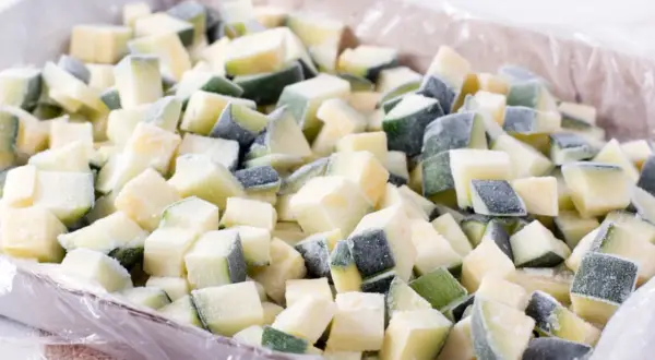 Gefrorene Zucchiniewürfel in einer Schale, bereit für die Lagerung. Perfekt für das zucchini einfrieren und spätere Verwendung in Gerichten.