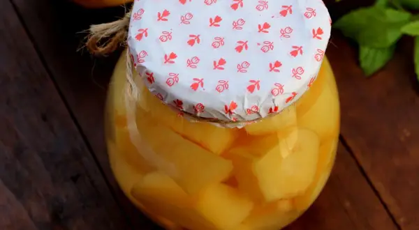 Ein Glas mit leckerem Quittenkompott, liebevoll mit einem gemusterten Papier und Juteband verschlossen.