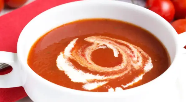Eine cremige Tomatensuppe, perfekt für ein Tomatensuppe Rezept mit frischen Tomaten. Mit einem Swirl aus Sahne verziert.