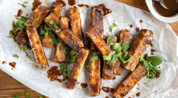 Marinierter Tofu, knusprig gebraten und mit einer dunklen Sauce beträufelt, garniert mit frischem Koriander. Perfekt zum **Tofu marinieren** und Genießen.