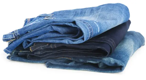 Gestapelte Jeans in verschiedenen Blautönen. Die Herstellung von Jeans verbraucht viel Wasser.
