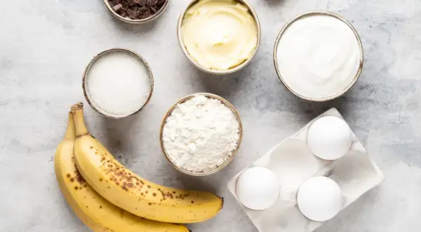 Reife Bananen, Mehl, Zucker, Butter, Eier, Schokolade und Joghurt – alles bereit, um die Bananen zu verwerten und etwas Leckeres zu backen.