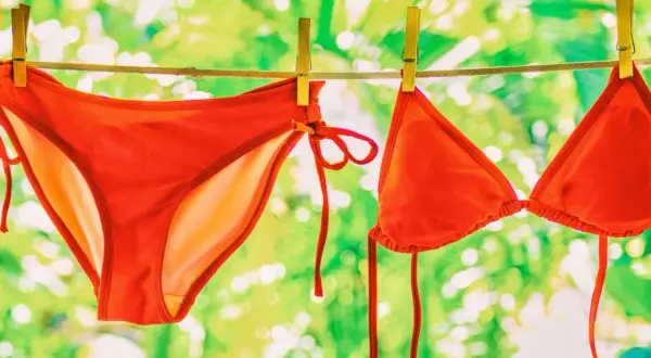Roter Bikini trocknet an der Leine. Nach dem **Bikini waschen** duftet er frisch nach Sommer.