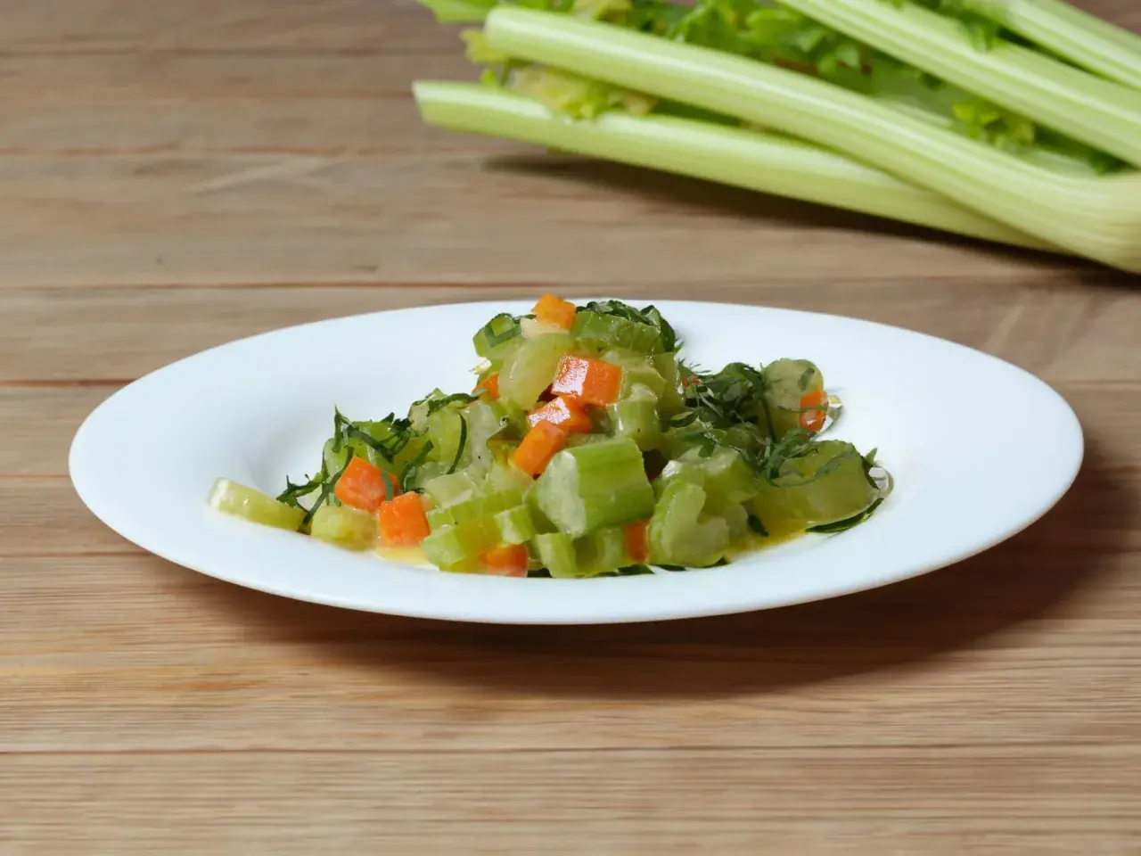 Gedünsteter Staudensellerie mit Karotten und Kräutern auf einem Teller, inspiriert von Staudensellerie Rezepten.
