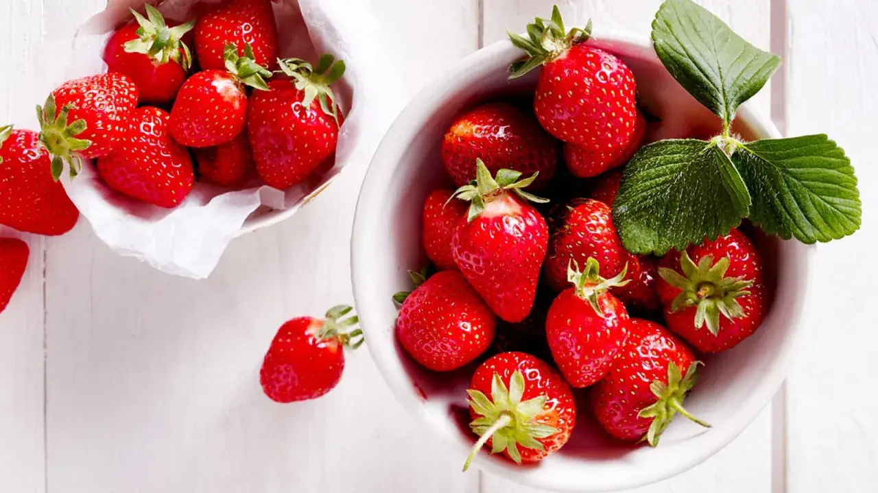 Frische, rote Erdbeeren in einer Schale und einem Körbchen, bereit, um sie frisch zu halten.