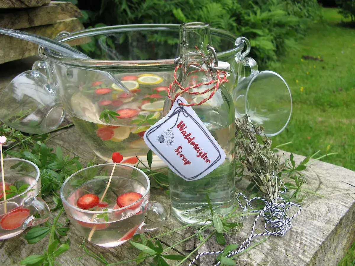 Erfrischender Waldmeister-Sirup für leckere Waldmeister Rezepte. Mit Erdbeeren und Zitrone im Punsch.