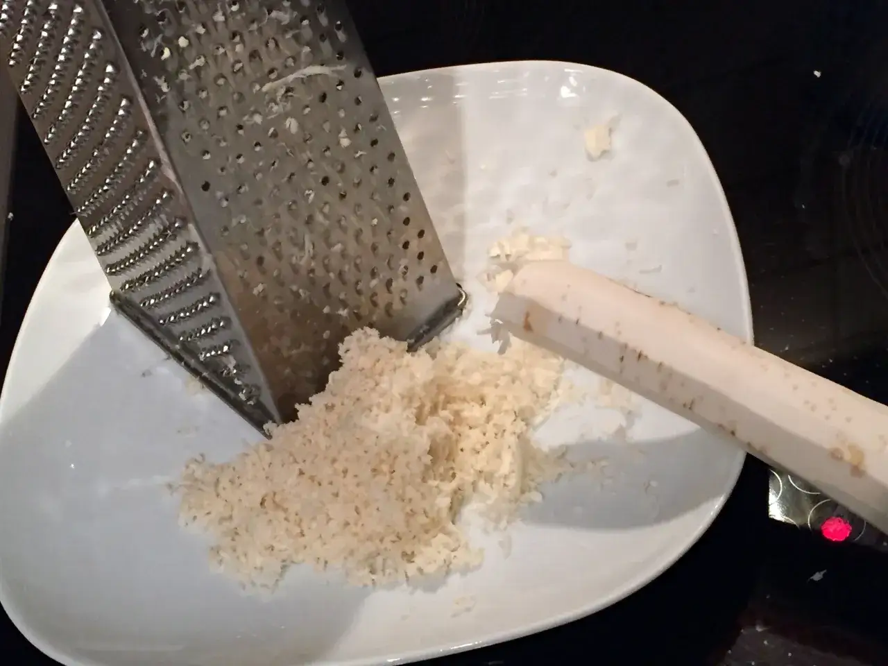Ein St&uuml;ck Meerrettich wird gerieben. Frische Zutaten f&uuml;r Meerrettich Rezepte.