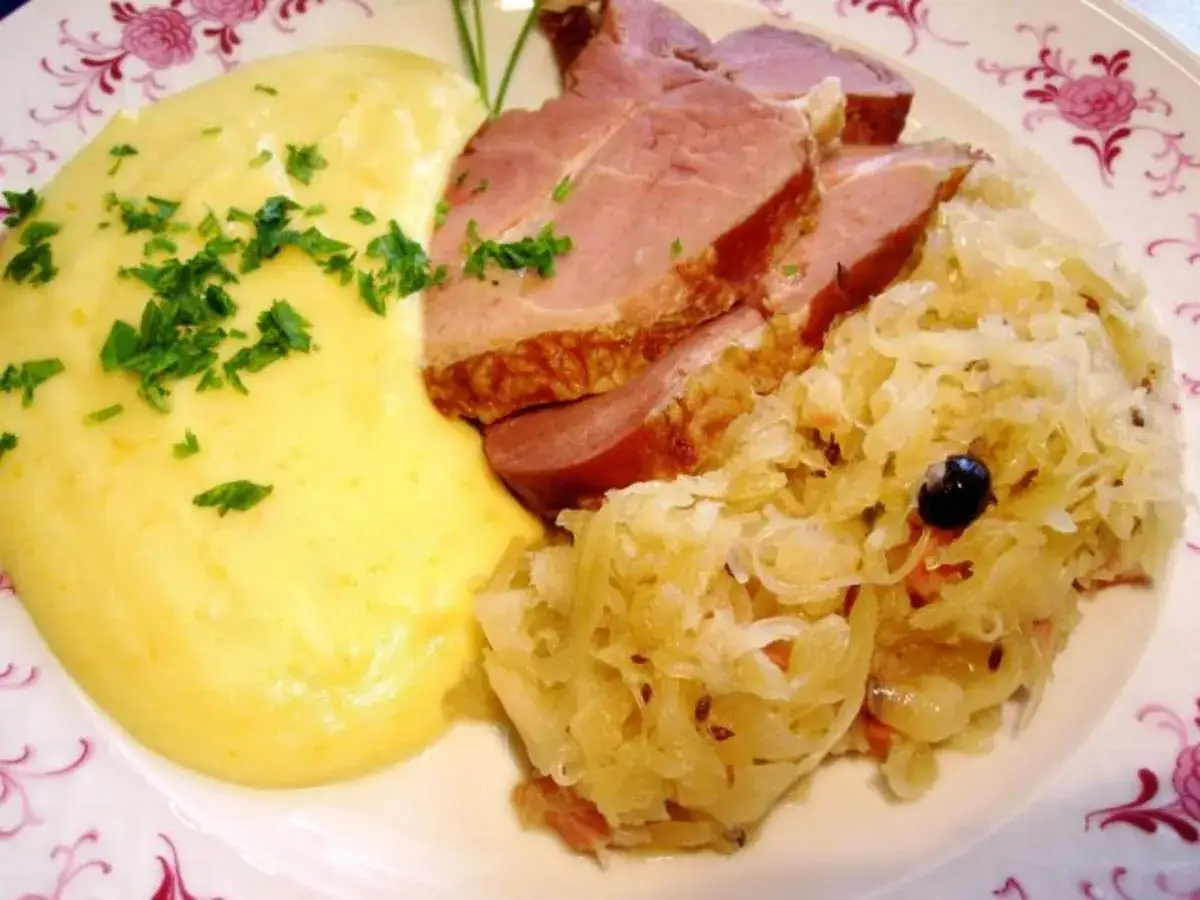 Schmackhaftes Gericht mit deftigem Schweinebraten, cremigem Kartoffelbrei und herzhaftem Sauerkraut. Perfekt zum Sauerkraut kochen!