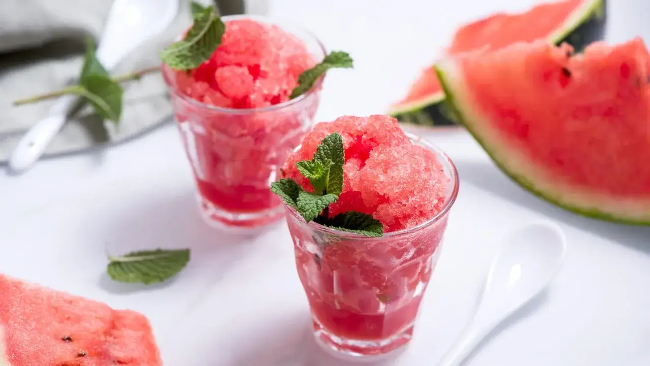 Erfrischendes Wassermelonen-Sorbet in Gläsern, garniert mit Minze. Ja, man kann Wassermelone einfrieren und daraus dieses leckere Dessert zaubern.