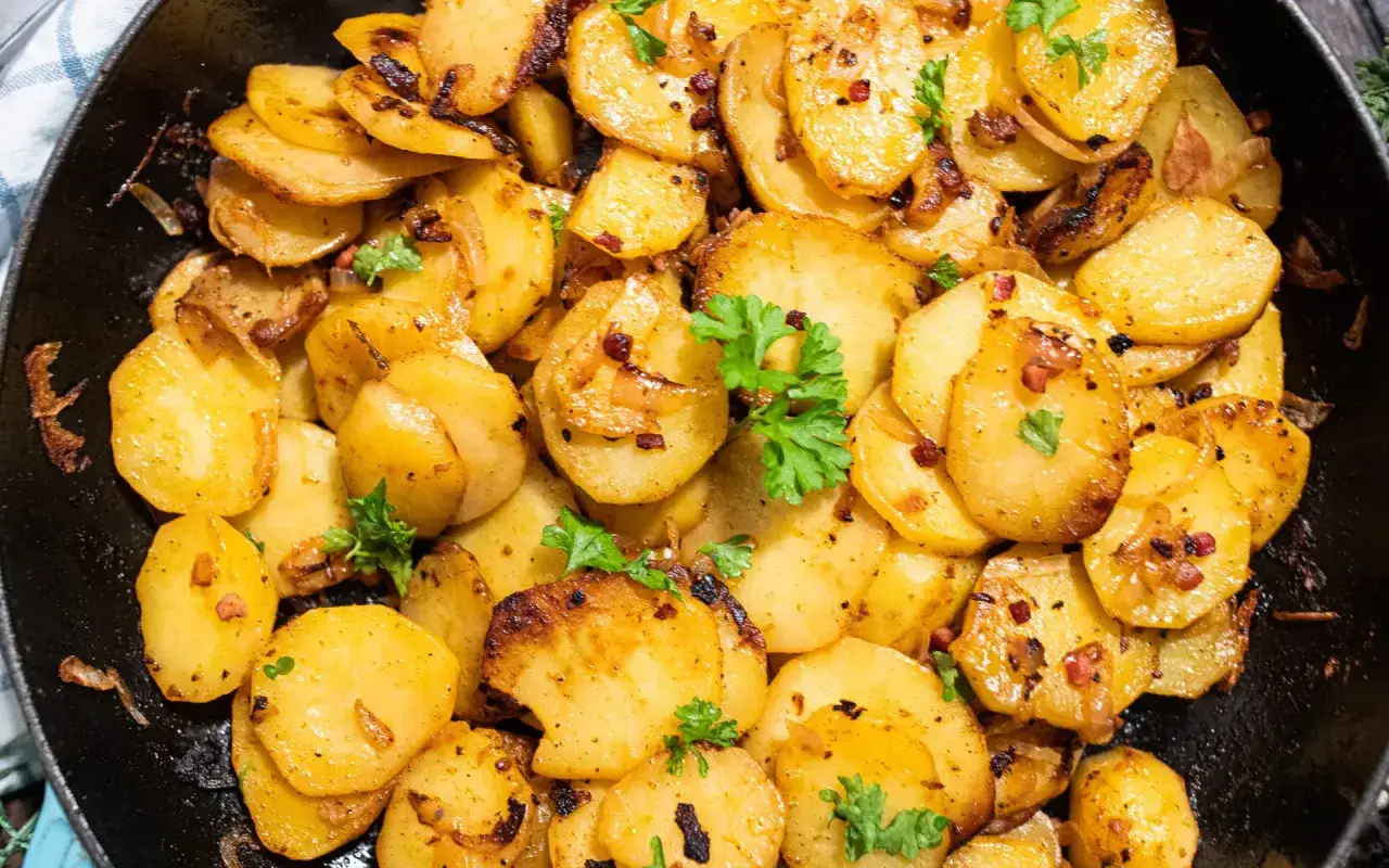 Goldbraune bratkartoffeln ohne vorkochen, knusprig gebraten mit Speck und Zwiebeln, garniert mit Petersilie. Ein Genuss!