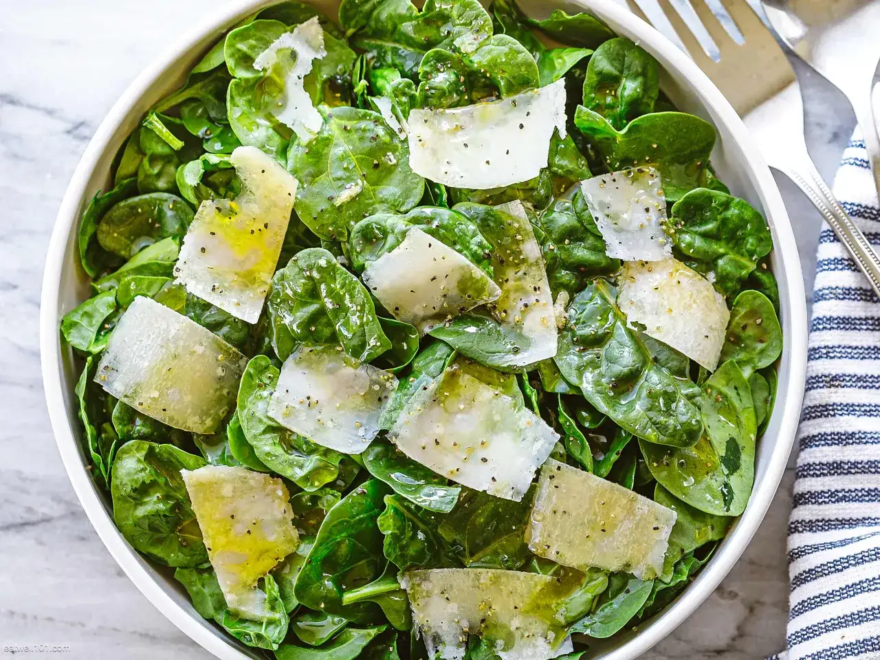Frischer Spinatsalat mit Parmesan und einem leichten Dressing. Perfekt, um Spinat kalt zu essen und eine gesunde Mahlzeit zu genießen.