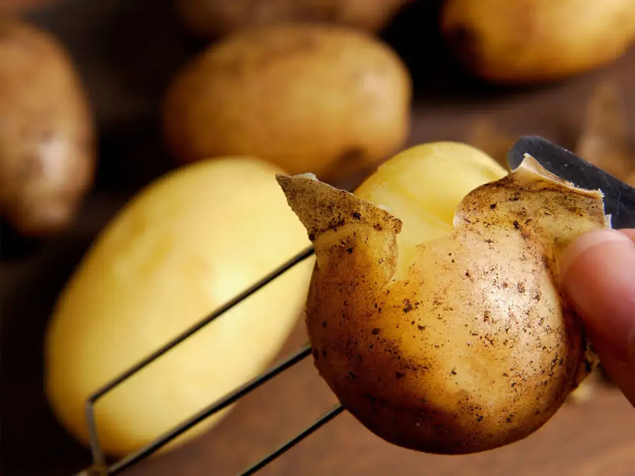 Frische Kartoffeln werden geschält, um sie mit Schale zu essen.