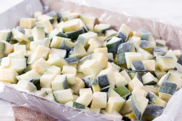 Gefrorene Zucchiniewürfel in einer Schale, bereit für die Lagerung. Perfekt für das zucchini einfrieren und spätere Verwendung in Gerichten.