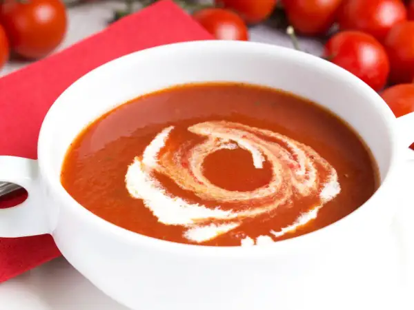Eine cremige Tomatensuppe, perfekt für ein Tomatensuppe Rezept mit frischen Tomaten. Mit einem Swirl aus Sahne verziert.
