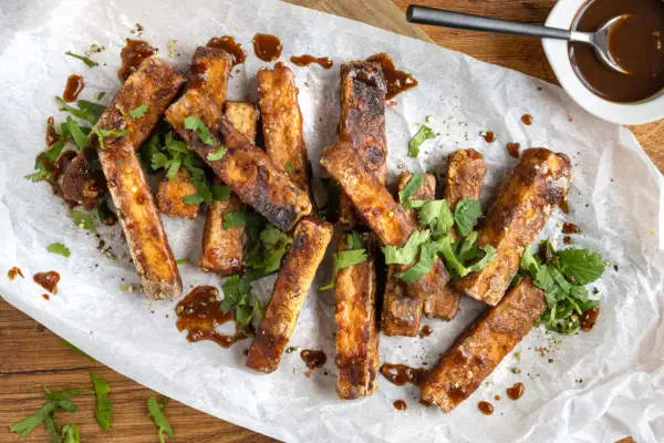 Marinierter Tofu, knusprig gebraten und mit einer dunklen Sauce beträufelt, garniert mit frischem Koriander. Perfekt zum **Tofu marinieren** und Genießen.