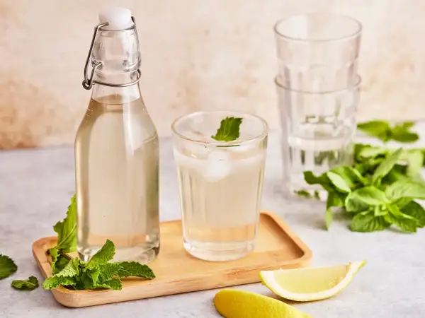 Erfrischendes Getränk mit selbstgemachtem Pfefferminzsirup, Eis, Minze und Zitrone. Perfekt zum pfefferminzsirup selber machen.